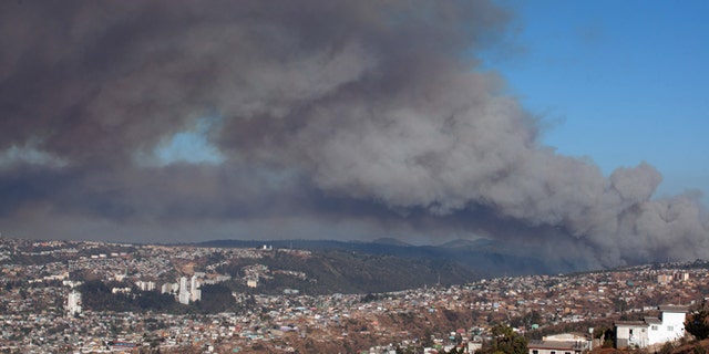 Plumes of smoke from a wild fire rise over Valparaiso, Chile, Friday, March 13, 2015. A serious forest fire spread quickly on Chile's coast Friday and threatened to reach the nearby port cities of Valparaiso and Vina del Mar. Deputy Interior Secretary Mahmud Aleuy said that thousands have been evacuated as flames advanced nearby. (AP Photo)
