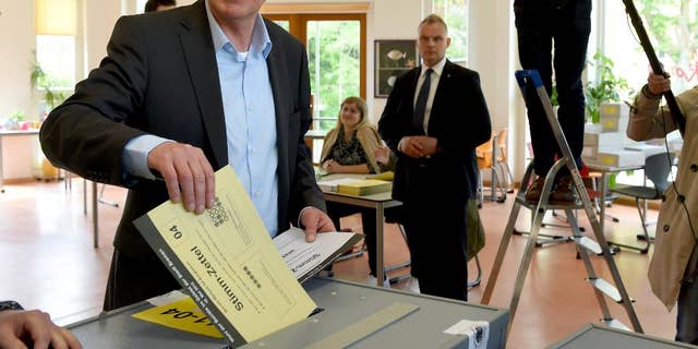 Mayor of Bremen Jens Boehrnsen casts his vote for the state election at a polling station in Bremen, Germany, Sunday, May 10, 2015. Germany's smallest state Bremen has been led by the center-left Social Democrats since the 1940s and polls point to a majority for popular Mayor Boehrnsen's current coalition with the Greens in the regional legislature. (Ingo Wagner/dpa via AP)
