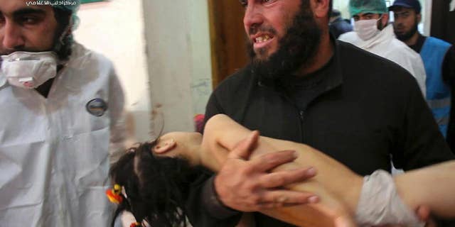 A man carries his child into a hospital following a chemical attack in Syria in April.