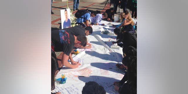 Students leave condolences on a banner for Nicolas Leslie, who was killed in France last week, during a vigil at the University of California, Berkeley Monday, July 18, 2016 in Berkeley, Calif. Leslie, 20, a Berkeley student who was killed in last week's Bastille Day truck attack in France was remembered Monday as an energetic and engaged member of the campus community. Leslie was an aspiring entrepreneur and environmentalist who participated in fraternity life and a student-run consulting group that provides marketing, research and social responsibility advice to businesses, student body President William Morrow said. (AP Photo/Lisa Leff)
