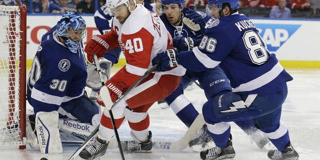 Detroit Red Wings left wing Henrik Zetterberg (40), of Sweden, is stopped by Tampa Bay Lightning goalie Ben Bishop (30), defenseman Braydon Coburn (55) and right wing Nikita Kucherov (86), of Russia, during the third period of Game 2 of a first-round NHL Stanley Cup hockey playoff series Saturday, April 18, 2015, in Tampa, Fla. The Lightning won the game 5-1. (AP Photo/Chris O'Meara)