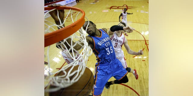 Oklahoma City Thunder's Kevin Durant (35) dunks the ball as Houston Rockets' Omer Asik (3) defends during the second half of Game 4 in a first-round NBA basketball playoff series Monday, April 29, 2013, in Houston. The Rockets beat the Thunder 105-103. (AP Photo/David J. Phillip)