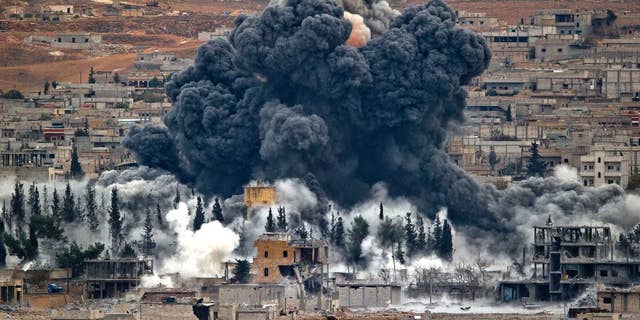 Smoke rises from the Syrian city of Kobani, following an airstrike by the U.S.-led coalition in November. (AP Photo/Vadim Ghirda, File)