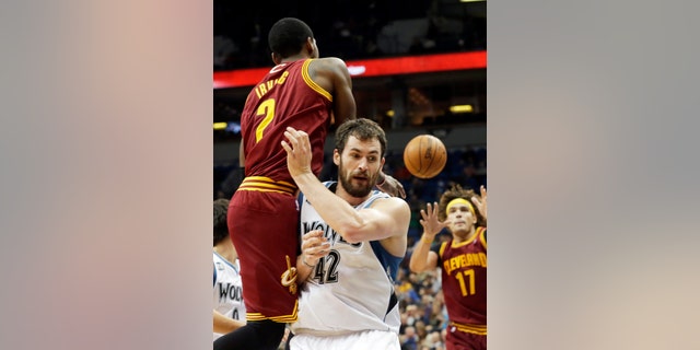 Cleveland Cavaliers' Kyrie Irving, left, gets off a pass to Anderson Varejao, right, of Brazil, as he runs into Minnesota Timberwolves' Kevin Love in the second half of an NBA basketball game Wednesday, Nov. 13, 2013, in Minneapolis. The Timberwolves won 124-95. Irving led the Cavaliers with 20 points. (AP Photo/Jim Mone)