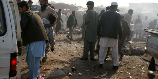 Jan. 10, 2012: A man carries an injured person to a vehicle after an explosion in Pakistani tribal area of Khyber near Peshawar, Pakistan.