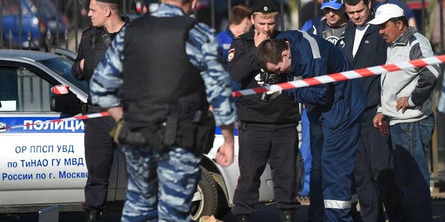 Police investigators work on the site of a brawl at the Khovanskoye cemetery in in Moscow, Russia, Saturday, May 14, 2016. Moscow police say a brawl at a cemetery involving up to 200 people has left two people dead and 10 wounded. Russian news reports cited police as saying the brawl was believed to have been about control over providing burial services at the sprawling Khovanskoye cemetery in southwest Moscow. (AP Photo)