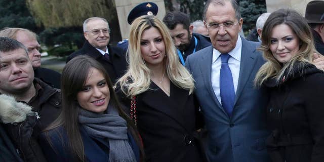 In this photo taken Monday, Dec. 12, 2016, Russian Foreign Minister Sergey Lavrov, second from right, poses for photos with members of a far-right pro-Russian group with Nemanja Ristic at first left, in Belgrade, Serbia. Serbian police have arrested two Serbs sought by Montenegro for alleged involvement in a pro-Russian plot to overthrow the Balkan country's government. Police said Friday that Nemanja Ristic and Predrag Bogicevic were arrested on an international warrant issued by Montenegro. It was not immediately clear when they could be extradited. (AP Photo, File)