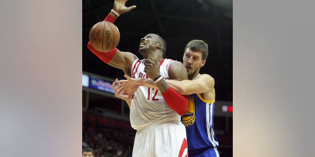 Houston Rockets Dwight Howard, left, gets fouled by Golden State Warriors defender David Lee during the first half of an NBA preseason basketball game in Hidalgo, Texas, Sunday, Oct. 19, 2014. (AP Photo/Delcia Lopez)