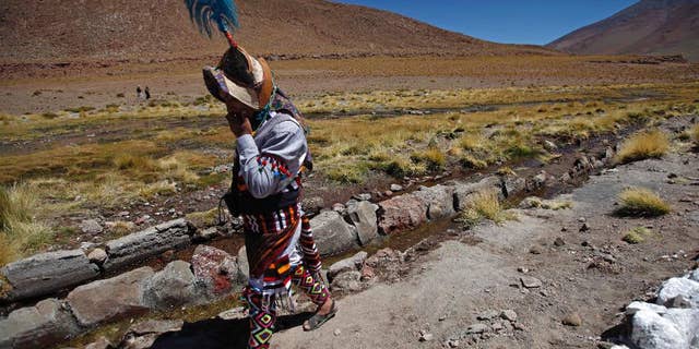 FILE - In this March 28, 2013, file photo, a Quechua indigenous man walks beside the stream of the Silala river in Potosi state, Bolivia. Bolivian President Evo Morales said on Saturday, March 26, 2016, that his country would sue Chile in the Netherlands-based International Court of Justice seeking to force Chile to pay compensation for using the Silala river in a border region. (AP Photo/Juan Karita, File)
