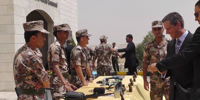Members of the Jordanian border guard, left, stand behind a table where various devices for first detection of possible chemical or biological weapons materials are displayed for visitors at their headquarters near the city of Zarqa, Jordan on Monday, June 8, 2015. The devices are part of a partially U.S.-funded program to improve Jordan’s surveillance of its borders with Syria and Iraq and to prevent infiltration of militants, including from the extremist group Islamic State, as well as the possible influx of weapons. (AP Photos/Karin Laub)