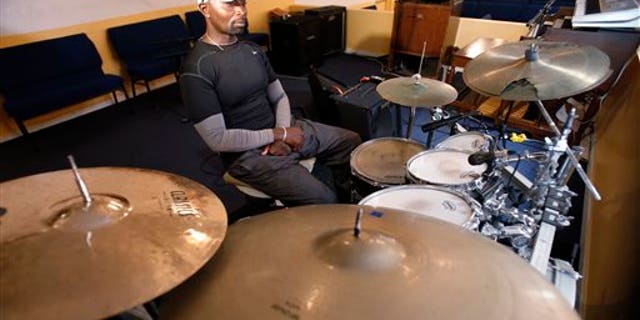 Fred Banks, uncle of 31-year-old Corey Jones who was shot and killed by a South Florida police officer, sits at the drum set that Jones played in church. (AP Photo/Wilfredo Lee)
