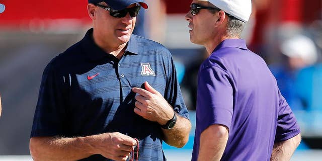 Arizona head coach Rich Rodriguez, left, and Washington head coach Chris Petersen talk before an NCAA college football game, Saturday, Nov. 15, 2014, in Tucson, Ariz. (AP Photo/Rick Scuteri)