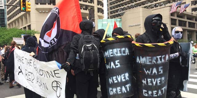 Protesters march in a May Day demonstration on Monday, May 1, 2017, near City Hall in Philadelphia. Public school teachers, immigration advocates and social and racial justice groups took to the streets in May Day demonstrations across Pennsylvania, with many inspired to vent about President Donald Trump's 101st day in office. (AP Photo/Kristen De Groot)