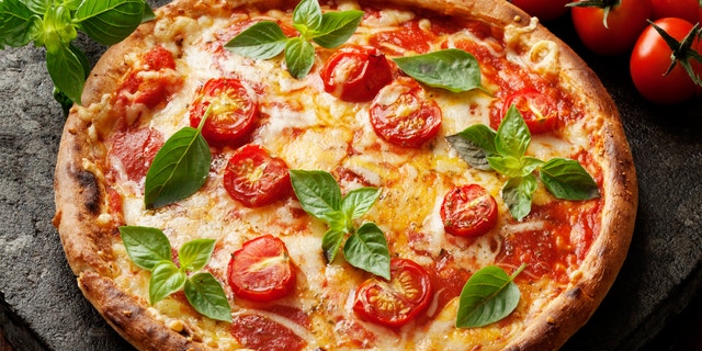 rustic italian pizza with mozzarella, cheese and basil leaves
