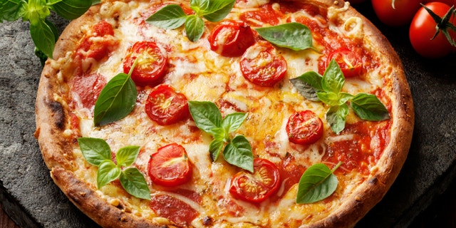 rustic italian pizza with mozzarella, cheese and basil leaves