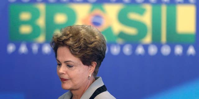 Brazil's President Dilma Rousseff leaves at the end of a government ceremony at the Planalto presidential palace in Brasilia, Brazil, Monday, March 16, 2015. Massive protests calling for Rousseff's impeachment on Sunday have narrowed her options to fend off political and economic crises, but her ouster remains highly unlikely, analysts said Monday. (AP Photo/Eraldo Peres)