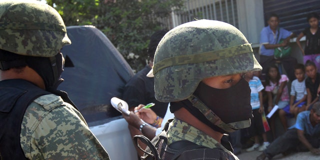 ACAPULCO, MEXICO - MARCH 03: Mexican marines stand guard at the site of a suspected drug-related execution on March 3, 2012 near Acapulco, Mexico. Drug violence has surged in the coastal resort in the last year, making Acapulco the second most deadly city in Mexico after Juarez. One of Mexico's top tourist destinations, Acapulco has suffered a drop in business, especially from foreign tourists, due to the violence. Toursim accounts for about 70 percent of the economy of Acapulco's state of Guerrero and 9 percent of Mexico's economy. (Photo by John Moore/Getty Images)