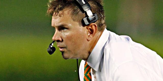 Miami coach Al Golden watches his team during the first half of their NCAA college football game against Louisville in Louisville, Ky., Monday, Sept. 1, 2014. (AP Photo/Garry Jones)