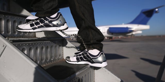 MESA, AZ - FEBRUARY 28:  A Honduran immigration detainee, his feet shackled and shoes laceless as a security precaution, boards a deportation flight to San Pedro Sula, Honduras on February 28, 2013 in Mesa, Arizona. U.S. Immigration and Customs Enforcement (ICE), operates 4-5 flights per week from Mesa to Central America, deporting hundreds of undocumented immigrants detained in western states of the U.S. With the possibility of federal budget sequestration, Most detainees typically remain in custody for several weeks before they are deported to their home country, while others remain for longer periods while their immigration cases work through the courts.  (Photo by John Moore/Getty Images)