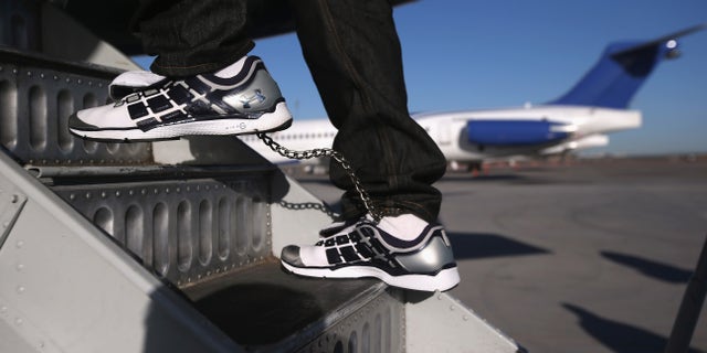 MESA, AZ - FEBRUARY 28: A Honduran immigration detainee, his feet shackled and shoes laceless as a security precaution, boards a deportation flight to San Pedro Sula, Honduras on February 28, 2013 in Mesa, Arizona. U.S. Immigration and Customs Enforcement (ICE), operates 4-5 flights per week from Mesa to Central America, deporting hundreds of undocumented immigrants detained in western states of the U.S. With the possibility of federal budget sequestration, Most detainees typically remain in custody for several weeks before they are deported to their home country, while others remain for longer periods while their immigration cases work through the courts. (Photo by John Moore/Getty Images)