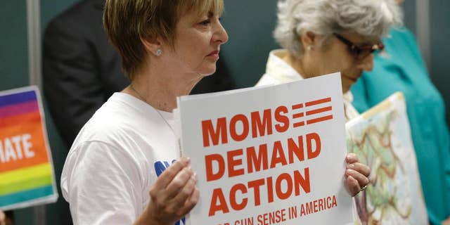 Kathryn Reeve, with the group Moms Demand Action, left, listens during a news conference, Tuesday, July 5, 2016, in Fort Lauderdale, Fla., where Congresswoman Debbie Wasserman Schultz, D-Fla. and other community leaders demanded action by House Speaker Paul Ryan to allow a vote on gun legislation. The House won't vote on proposed Democratic gun curbs, Speaker Paul Ryan suggested Tuesday as the rekindled election-year clash over firearms showed no sign of resolution. (AP Photo/Lynne Sladky)