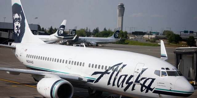 In this June 11, 2009 file photo, an Alaska Airlines airliner is pushed away from a gate at SeaTac Airport in SeaTac, Wash.
