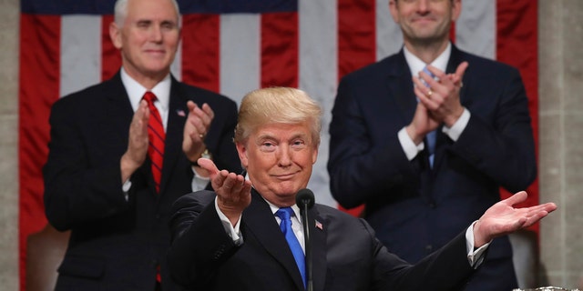 President Donald Trump gestures as delivers his first State of the Union address in the House chamber of the U.S. Capitol to a joint session of Congress Tuesday, Jan. 30, 2018 in Washington, as Vice President Mike Pence and House Speaker Paul Ryan applaud. (Win McNamee/Pool via AP)