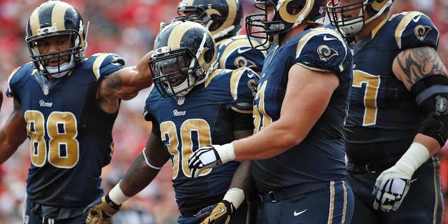 St. Louis Rams running back Zac Stacy (30) celebrates with teammates, including tight end Lance Kendricks (88) and center Tim Barnes (61), after scoring against the Tampa Bay Buccaneers during the first quarter of an NFL football game Sunday, Sept. 14, 2014, in Tampa, Fla. (AP Photo/Brian Blanco)