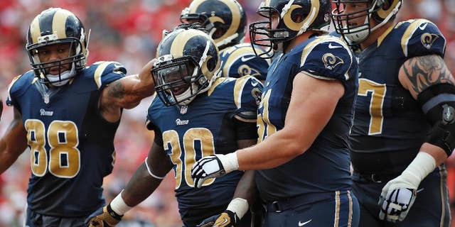 St. Louis Rams running back Zac Stacy (30) celebrates with teammates, including tight end Lance Kendricks (88) and center Tim Barnes (61), after scoring against the Tampa Bay Buccaneers during the first quarter of an NFL football game Sunday, Sept. 14, 2014, in Tampa, Fla. (AP Photo/Brian Blanco)