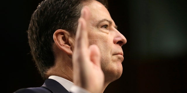 Former FBI Director James Comey is sworn in before testifying before a Senate Intelligence Committee hearing on Russia's alleged interference in the 2016 U.S. presidential election on Capitol Hill in Washington, U.S., June 8, 2017. REUTERS/Jim Bourg - RTX39NMM