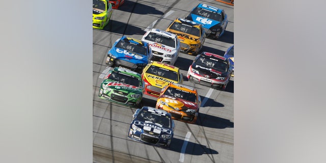 Sprint Cup Series driver Jimmie Johnson (48) leads a pack of cars including driver Dale Earnhardt Jr. (88) and driver Kyle Busch (18) through the tri-oval during the NASCAR Sprint Cup Series auto race at the Talladega Superspeedway in Talladega, Ala., Sunday, Oct. 20, 2013. (AP Photo/Butch Dill)
