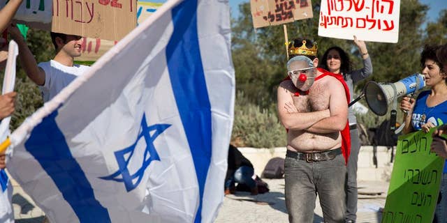 File - In this Sunday, Feb. 14, 2016 file photo, an activist wears a mask bearing a portrait of Prime Minister Benjamin Netanyahu during a protest against a natural gas deal signed in December, 2015 with U.S. and Israeli developers for drilling offshore gas deposits, in front of the Supreme Court in Jerusalem. Israel's Supreme Court has ruled against the governments framework deal for its natural gas reserves granting a year for issues to be worked out on Sunday, March 27, 2016. (AP Photo/Ariel Schalit, File)
