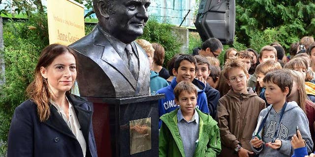 Anne Goscinny (L), daughter of the late French comic book writer Rene Goscinny, unveils a sculpture of her father at the French high school in Warsaw on September 25, 2013.