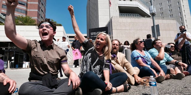 Protesters sat in the street on Monday in downtown Los Angeles to block entry to an ICE facility.