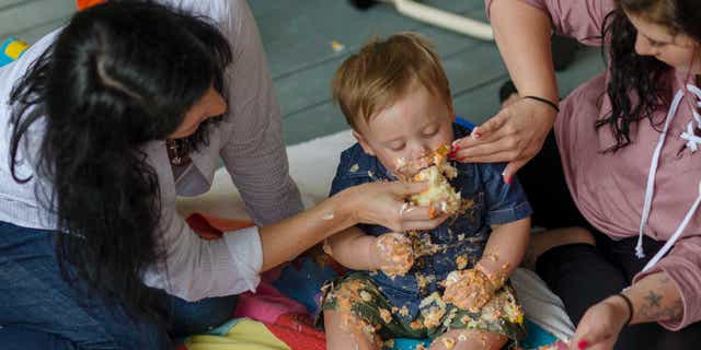 Temple Phipps (left) Vaughn and Samantha Snipes (right) do a cake smash for Vaughn's birthday.