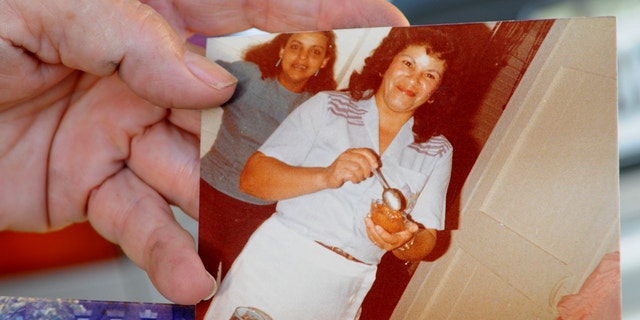 Miladys Ortega shows a photograph of her sister, Yoselyn Ortega, front center, taken some time between 1985 and 1990, at her home in Santiago, Dominican Republic, Saturday, Oct. 27, 2012.