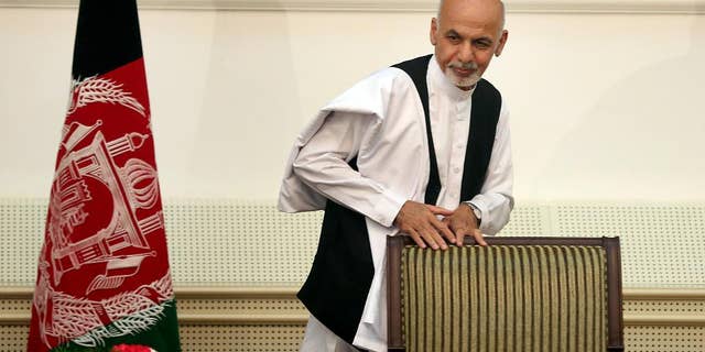Afghanistan's presidential election candidate Ashraf Ghani Ahmadzai leaves after signing a power-sharing deal at the presidential palace in Kabul, Afghanistan, Sunday, Sept. 21, 2014. Ahmadzai, who will become president, and Abdullah Abdullah signed the national unity government deal as outgoing President Hamid Karzai watched.(AP Photo/Massoud Hossaini)