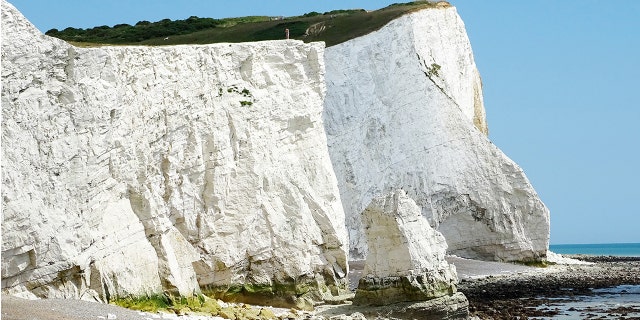 The edge of the cliff is fractured with cracks, and every year along the iconic white cliffs, hundreds of tonnes of rocks fall onto the beach below.