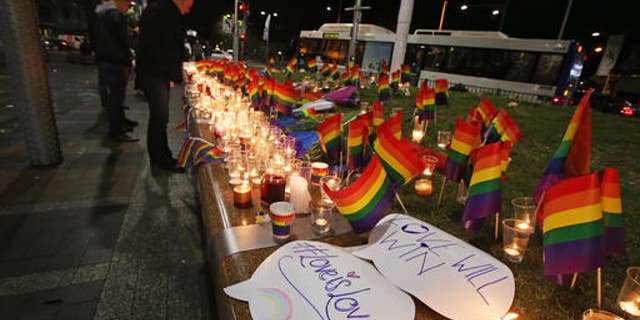 An impromptu memorial is set up in Sydney, Monday, June 13, 2016, following the Florida mass shooting at the Pulse Orlando nightclub where police say a gunman wielding an assault-type rifle opened fire, killing at least 50 people and wounding dozens. Australian Prime Minister Malcolm Turnbull said that the Orlando mass shooting was "an attack on all of us â on all our freedoms, the freedom to gather together, to celebrate, to share time with friends." (AP Photo/Rick Rycroft)