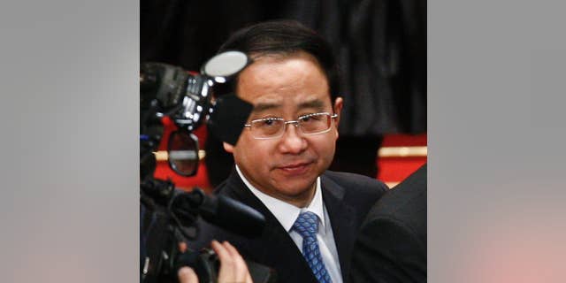 FILE - In this March 14, 2012, file photo, Ling Jihua, a loyal aide and confidante to President Hu Jintao, is seen as Chinese President Hu Jintao signs a document after attending the closing ceremony of the National People's Congress at the Great Hall of the People in Beijing. Chinese prosecutors have indicted the former top aide to ex-President Hu Jintao on charges of taking bribes, illegally obtaining state secrets and abuse of power, state media reported Friday, May 13, 2016 in the latest high-profile blow in President Xi Jinping's sweeping crackdown on corruption. (AP Photo/Andy Wong, File)