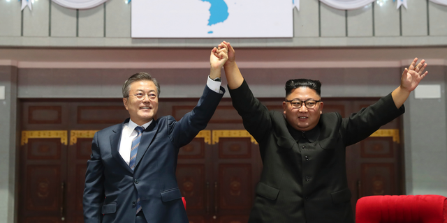 South Korean President Moon Jae-in and North Korean leader Kim Jong Un raise their hands after watching the mass games performance of "The Glorious Country" at May Day Stadium in Pyongyang, North Korea, Wednesday, Sept. 19, 2018. (Pyongyang Press Corps Pool via AP)