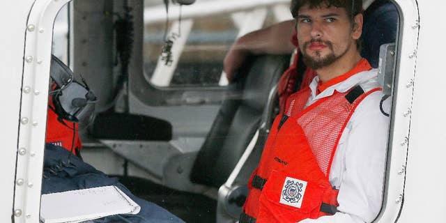 FILE- In this Sept. 27, 2016, file photo, Nathan Carman arrives in a small boat at the US Coast Guard station in Boston. Carman spent a week at sea in a life raft before being rescued by a passing freighter. Police have returned to the home of a man whose 2013 killing remains unsolved and whose daughter is presumed dead after she went out sailing with her son, Nathan Carman, and their boat sank this year. (AP Photo/Michael Dwyer, File)