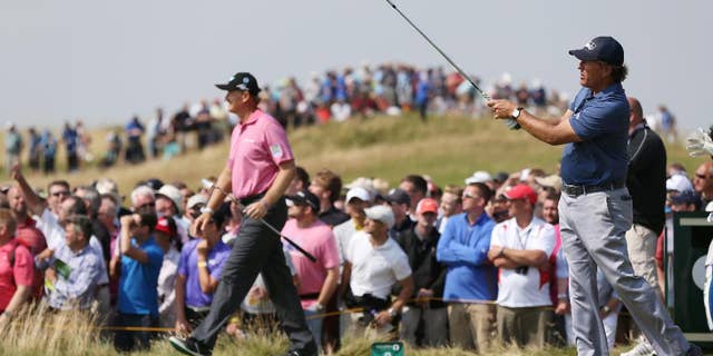 Phil Mickelson of the US plays his shot off the 9th tee box as Ernie Els of South Africa starts to walk along the fairway during the second day of the British Open Golf championship at the Royal Liverpool golf club, Hoylake, England, Friday July 18, 2014. (AP Photo/Scott Heppell)