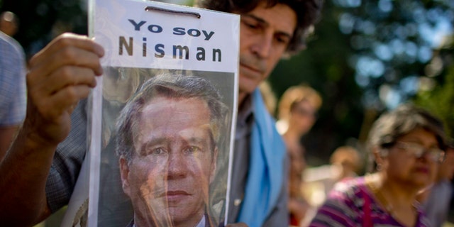 A demonstrator holds a photo of late prosecutor Alberto Nisman that reads in Spanish "I am Nisman" during an protest to demand justice after more than one month since his death outside a court house in Buenos Aires, Argentina, Wednesday, March 18, 2015. Nisman was found dead in his bathroom on January 18, on the eve of congressional hearings where he was due to present his accusations against President Cristina Fernandez of shielding Iranian officials from prosecution over the 1994 bombing of a Buenos Aires Jewish center. (AP Photo/Natacha Pisarenko)