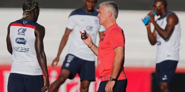 France's head coach Didier Deschamps talks to his layers during a during a training session at the Santa Cruz stadium, in Ribeirao Preto, Brazil, Saturday, June 21, 2014. France faces Ecuador, Switzerland and Honduras in group E of the World Cup. Having captured people's attention at the soccer World Cup with some scintillating attacking football, France's players are now in unknown territory after raising expectations back home, having routed Switzerland and Honduras. (AP Photo/David Vincent)