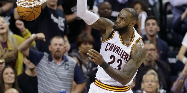 Cleveland Cavaliers forward LeBron James dunks against the Golden State Warriors during the first half of Game 4 of basketball's NBA Finals in Cleveland.