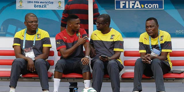 Cameroon's Samuel Eto’o, second from left, talks with a member of his team during an official training session the day before the group A World Cup soccer match between Brazil and Cameroon at the Estadio Nacional in Brasilia, Sunday, June 22, 2014. Cameroon began the tournament with a 1-0 loss to Mexico and a 4-0 defeat to Croatia and they will want to leave the World Cup by beating the hosts. (AP Photo/Andre Penner)
