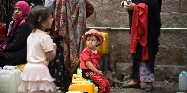 May 9, 2015: A girl waits for her turn to fill buckets with water from a public tap amid an acute shortage of water, in Sanaa, Yemen.