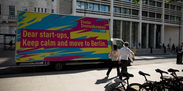 An advert suggesting start-up businesses based in the UK move to Berlin is displayed on a parked vehicle on Finsbury Square in the City of London, Tuesday, July 5, 2016. Its image as a relaxed and relatively affordable city may convince tech companies to relocate to Berlin, which is already home to online retailer Zalando, language-learning service babble and audio sharing platform SoundCloud. Last year, Berlin startups attracted more investment than those in based in London. (AP Photo/Matt Dunham)