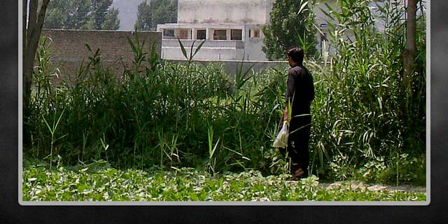 FILE: A local residents walks near a house where Al Qaeda leader Usama bin Laden was killed, Abbottabad, Pakistan.
